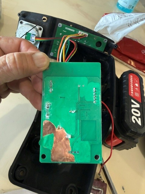 Opened yellow remote showing discoloration and corrosion on the printed circuit board.